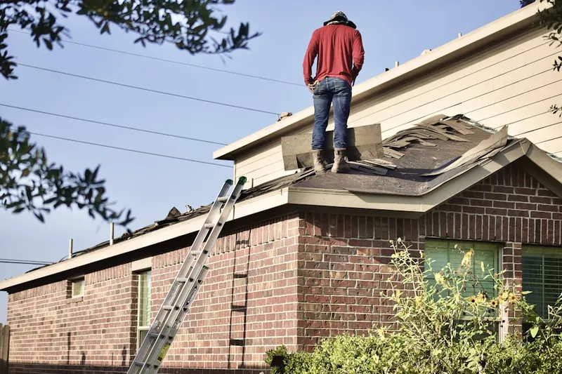 Professional roofer working on a residential roof in Northford
